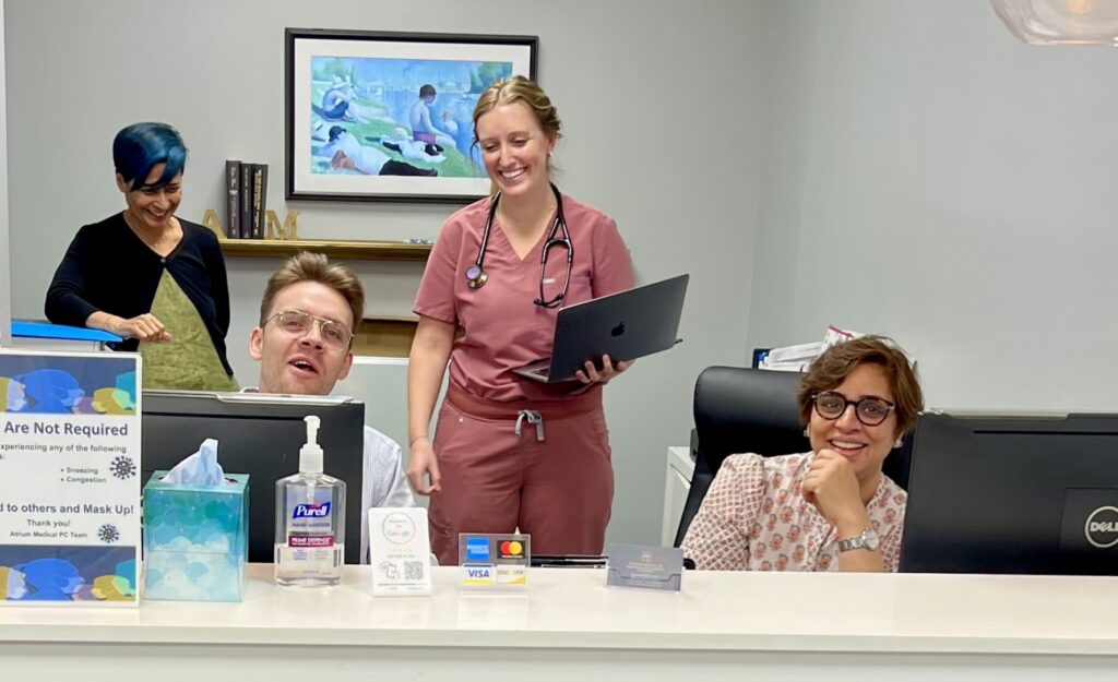 Atrium Medical Primary Care team at the front desk in the Midtown Manhattan office, helping patients with insurance, appointments, and primary care access.